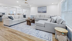 A modern living room with a sectional sofa, a coffee table, and a patterned rug.