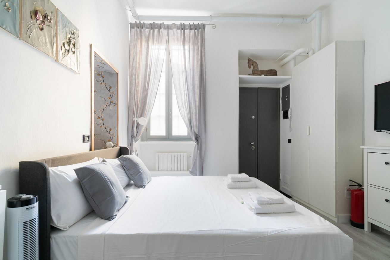Une chambre à coucher comprenant un lit, une armoire, un téléviseur et un radiateur.