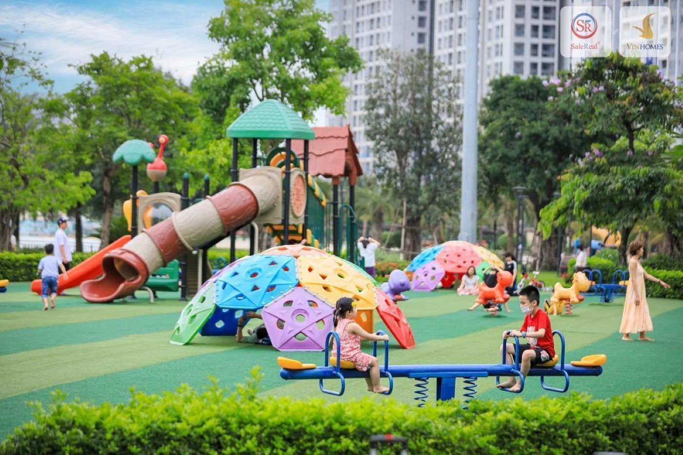 A playground with various play structures including a slide, climbing dome, and swings.