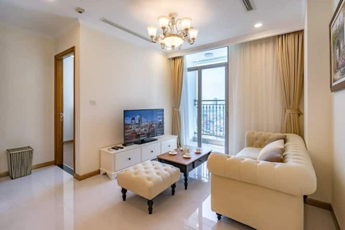 Un salon moderne avec un canapé, une table basse, un téléviseur et une vue sur le balcon.