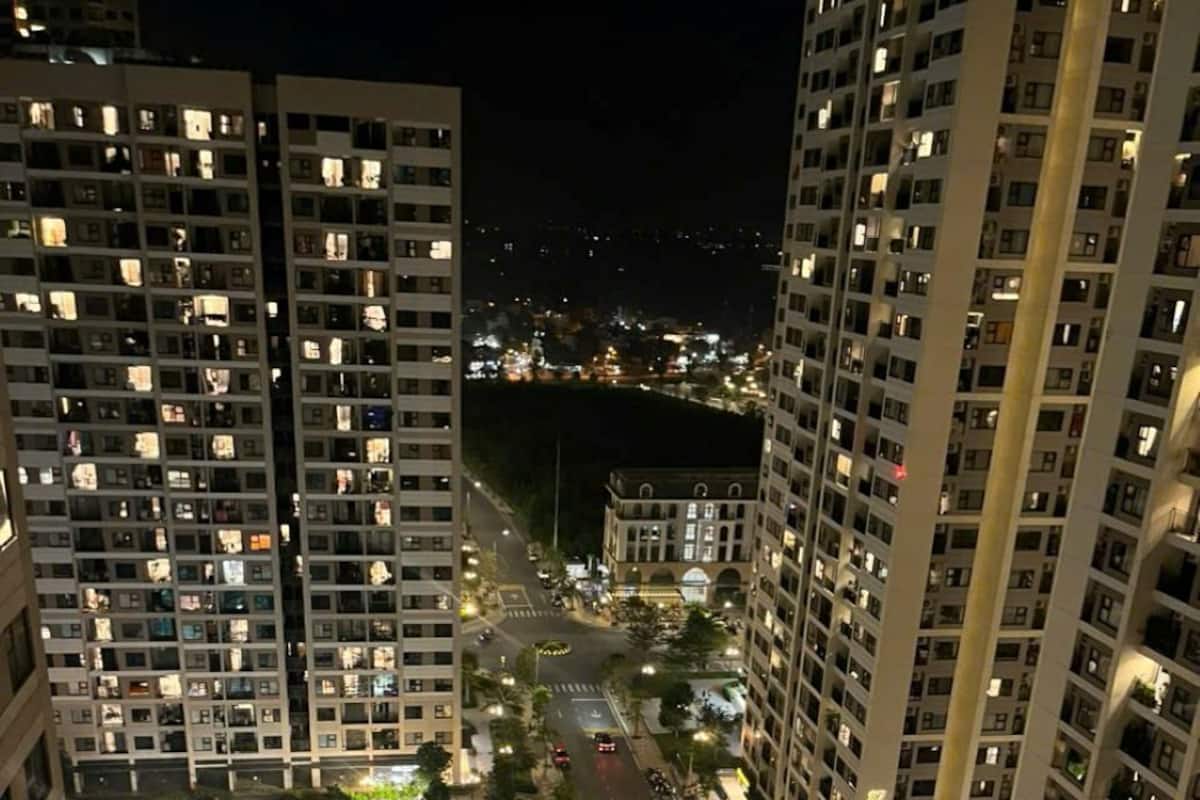 Un immeuble de grande hauteur, doté de nombreux étages, une cour intérieure avec une piscine et une rue bien éclairée.