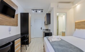 A modern hotel room with a bed, a desk, a chair, a TV, and a mirror. - Apt w/ Balcony & View, 650m From the Metro Nik0504 (São Paulo)
