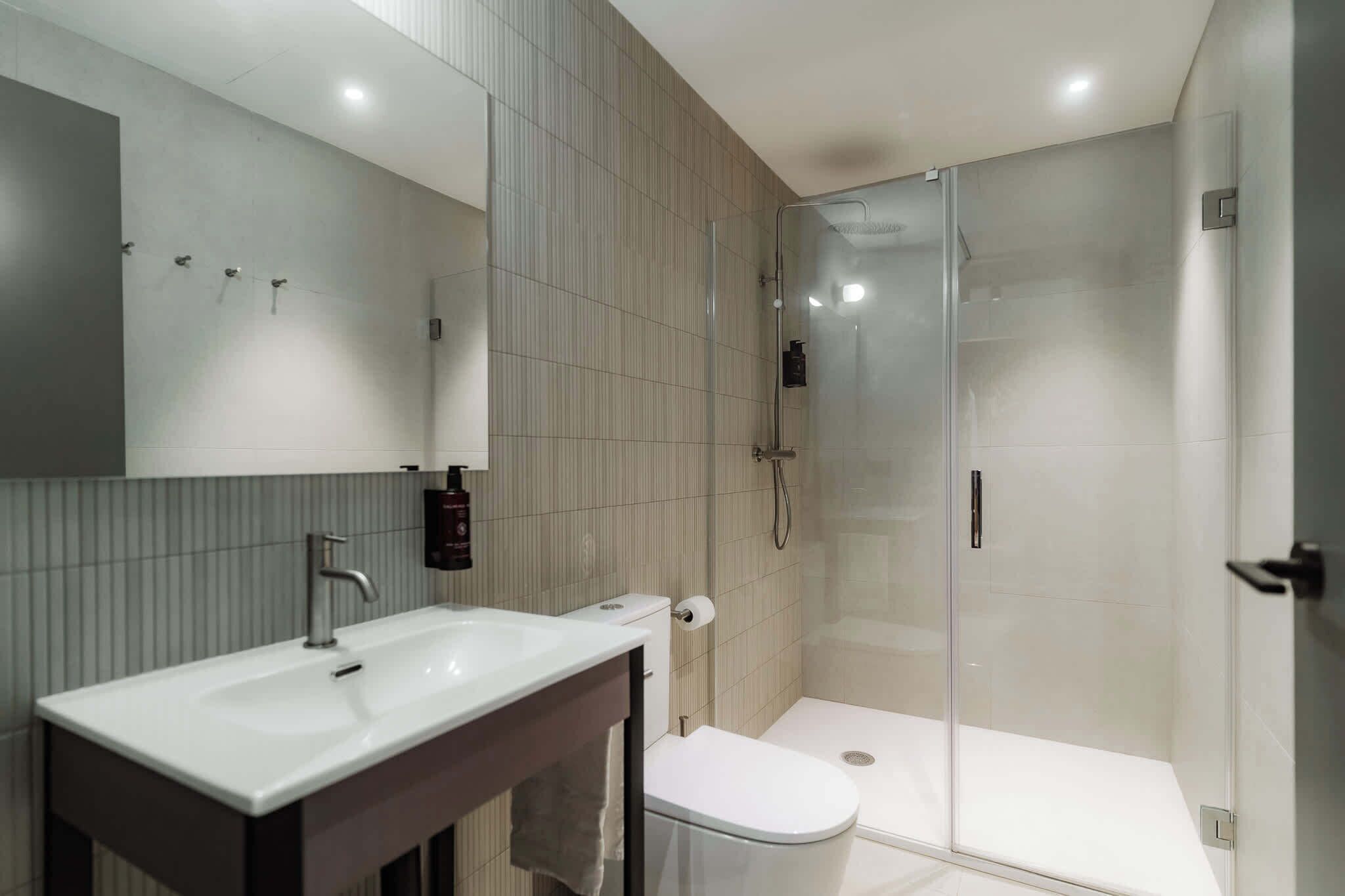 Familie suite | Badkamer | Een douche, een haardroger, handdoeken, zeep