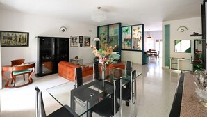 A spacious living room with a glass dining table, comfortable seating, and artwork on the walls. - GuestHost - Roomy and bright 140 sqm apartment, accommodating up to 4 people, located on the first floor of a building without an elevator.The property is located in a semi-central area of ​​Matera, well-served by public transport and a short distanc (Matera)