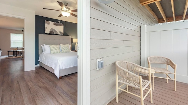 Un dormitorio con cama, ventilador de techo y mesita de noche.