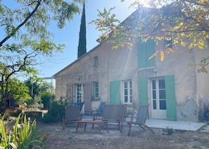 A rustic building with a garden patio featuring wooden furniture.
