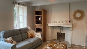A living room with a grey sofa, wooden coffee table, and a fireplace. - The farmhouse at the foot of the Ventoux (Carpentras)