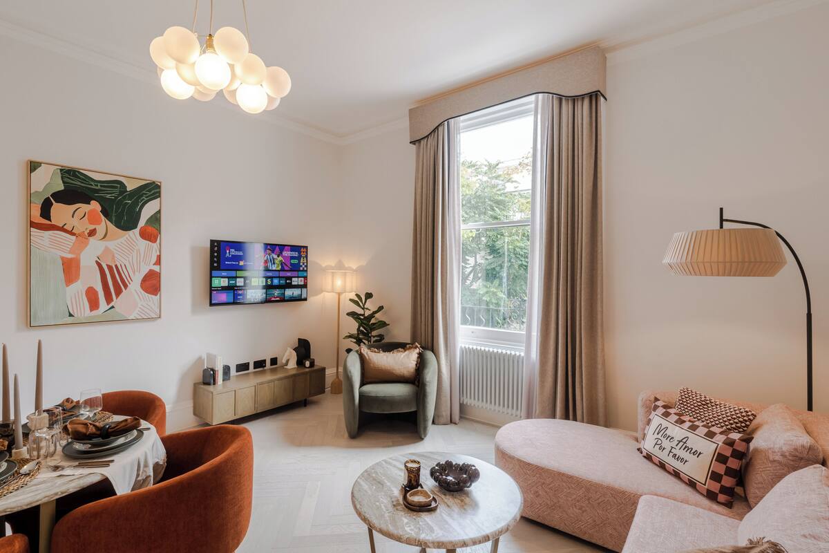 Uma sala de estar moderna com área de refeições, televisão e uma grande janela com cortinas.