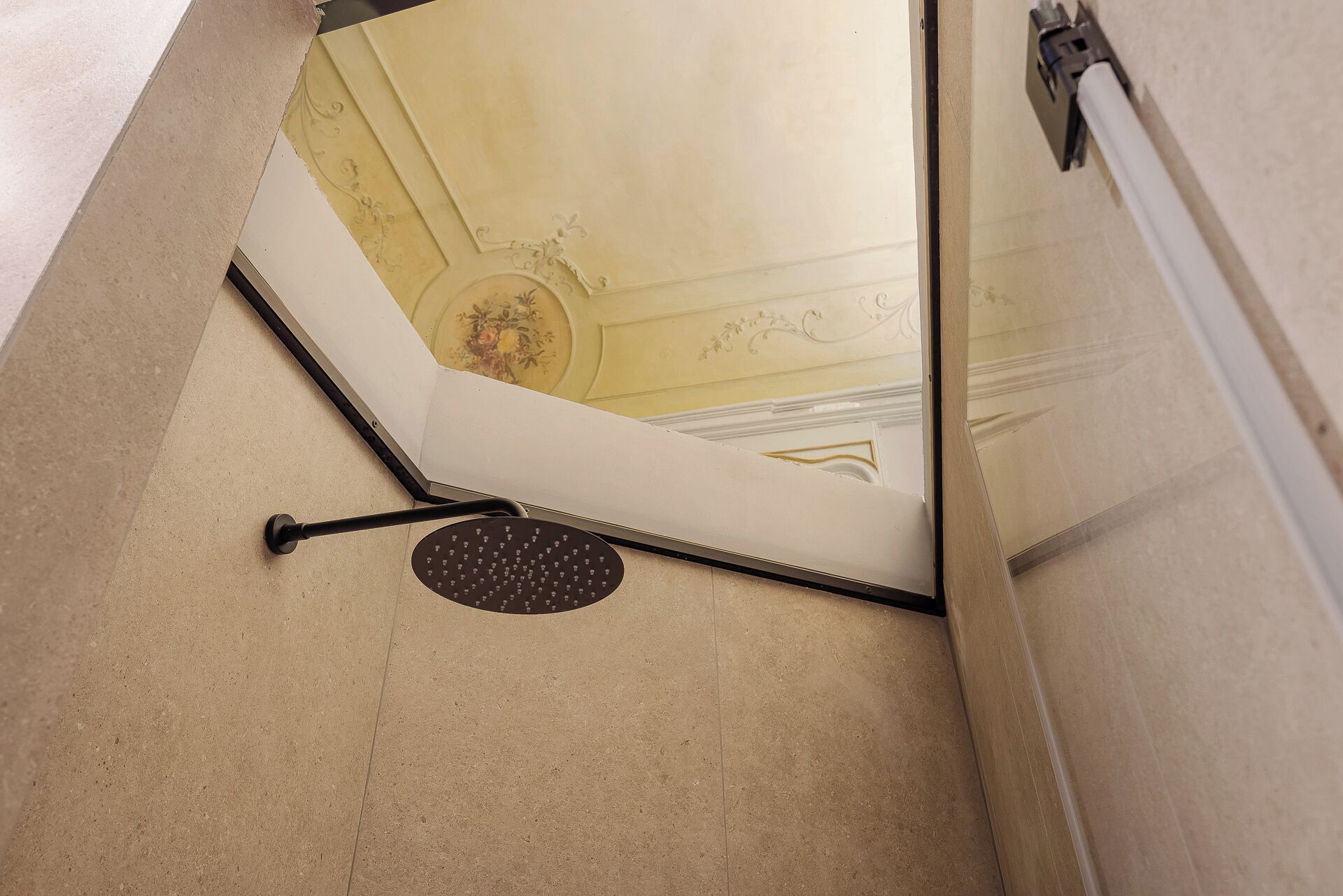 A corner of a room with a white door, a black floor mat, and a decorative ceiling with floral patterns.