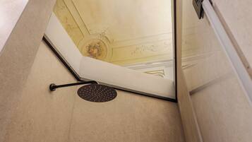 A corner of a room with a white door, a black floor mat, and a decorative ceiling with floral patterns.