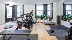 A gym with exercise equipment, mats, and potted plants. - Student Residence in the Heart of Montreal (Montréal)
