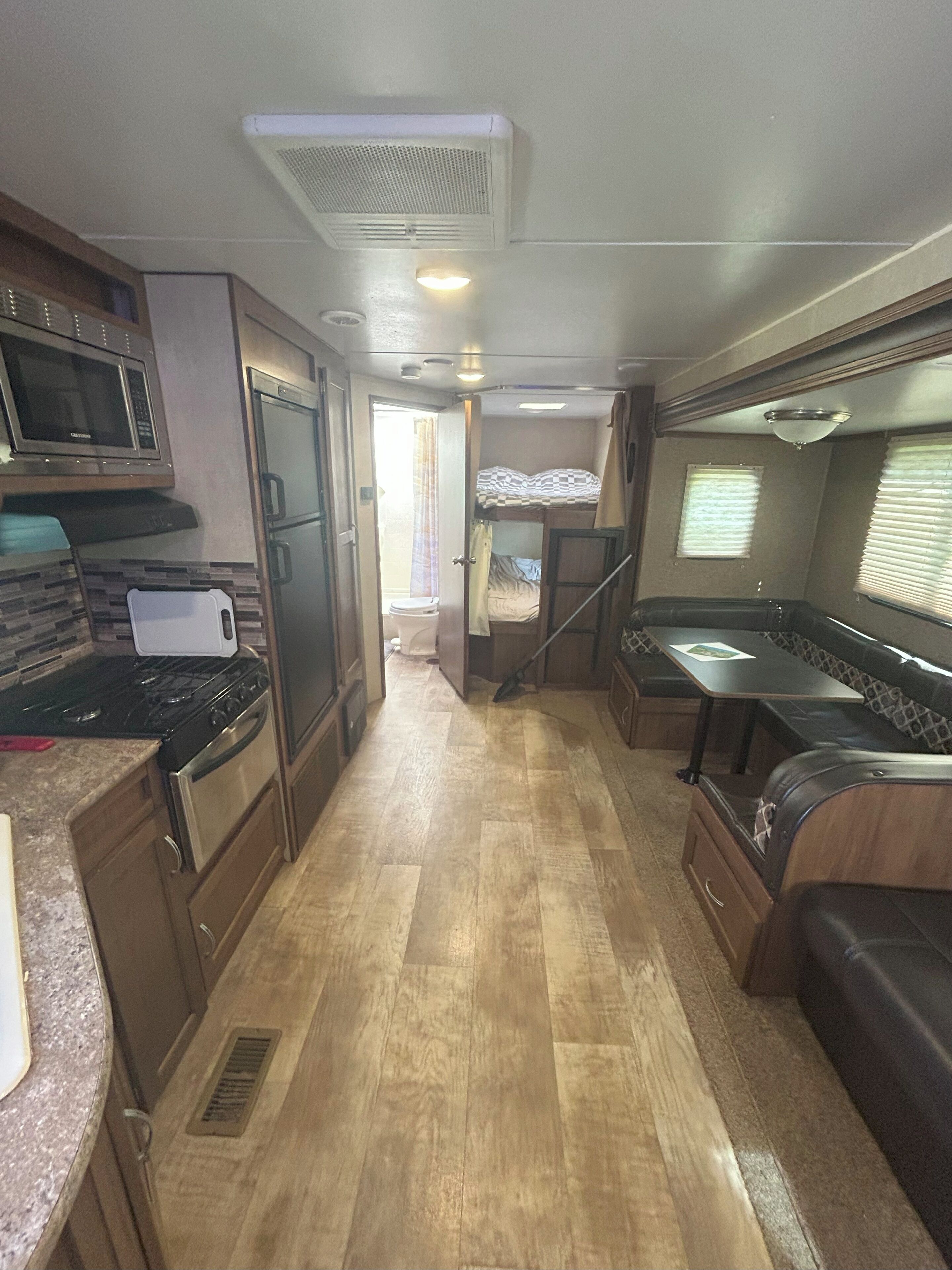Una cocina compacta para autocaravana con microondas, estufa y refrigerador.