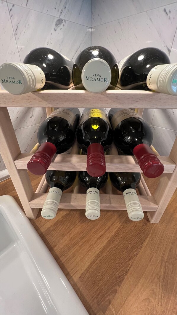 A wine rack with multiple bottles, some labeled 'Vina Mramor'.