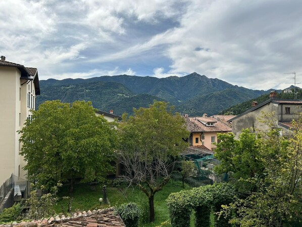 A residential area with houses, a tree, and mountains in the background.