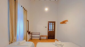 A hotel room with two beds, a wooden bench, a small table, a mirror, and a door. - Dadas Villa - A Private Villa in Kandy & Peaceful Escape for Families & Couples (Kundasale, Sri Lanka)