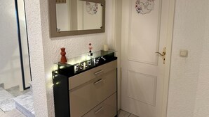 A bathroom with a mirror, a vanity with a glass top, and a door with a floral monogram. - Modern and comfortable house in Nidderau - ideal for families and couples (Nidderau)