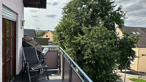A balcony with a view of a tree and houses. - Modern and comfortable house in Nidderau - ideal for families and couples (Nidderau)