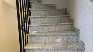 A set of marble stairs with black railings, leading to an upper floor. - Modern and comfortable house in Nidderau - ideal for families and couples (Nidderau)