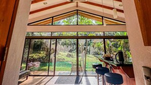 Une pièce spacieuse avec un plafond haut, de grandes fenêtres et un ventilateur de plafond.