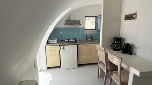 A compact kitchen with a dining area, featuring a built-in stove, sink, and a small refrigerator. - Leon Lux Apartment, double room. (Emporio)