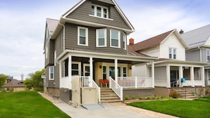 A two-story house with a front porch, a covered entryway, and a small front yard. - “Life is Good” | Accessible Stay Near the Falls (Niagara Falls)