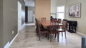 A dining area with a wooden table and chairs, a ceiling fan, and a painting on the wall. - “Life is Good” | Accessible Stay Near the Falls (Niagara Falls)
