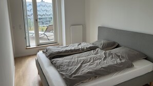 Una camera da letto con un letto, una finestra e vista su un edificio.