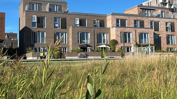 Un edificio residenziale a più piani con facciata in mattoni, ampie finestre e balconi.