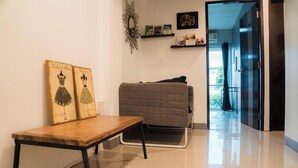 Una habitación moderna con una mesa de madera, un sofá gris y obras de arte en la pared.