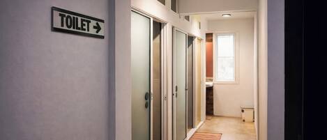 A hallway with a sign indicating the direction to the toilet.