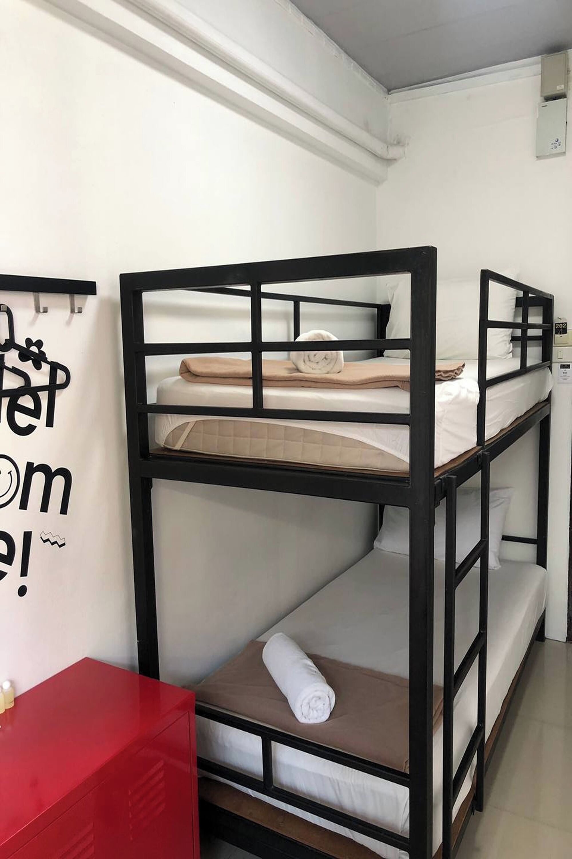 A bunk bed room with a red cabinet and a wall sign.