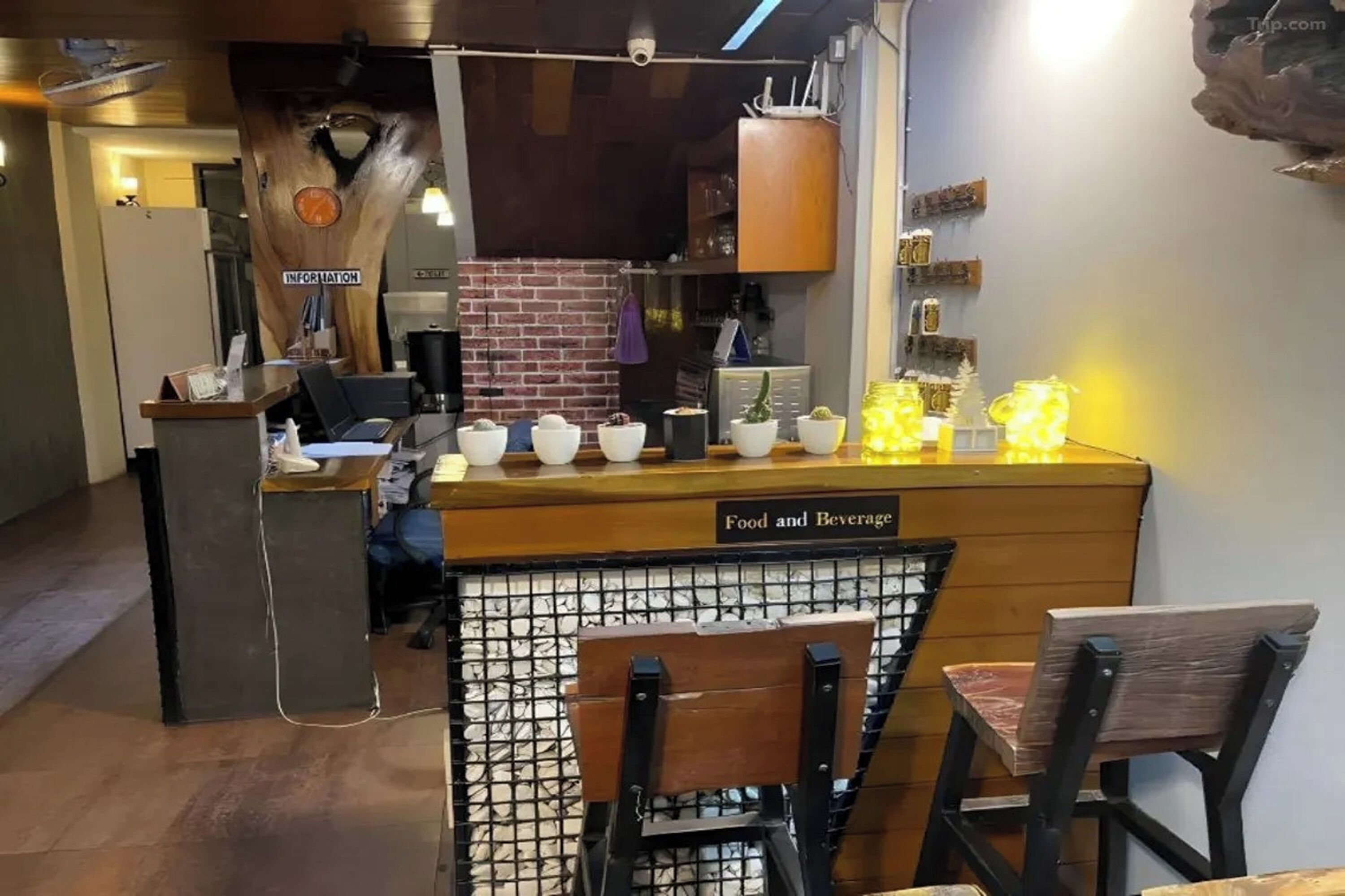 Un restaurante con mostrador de madera, un letrero que dice "Food and Beverage" y una pared de ladrillo al fondo.
