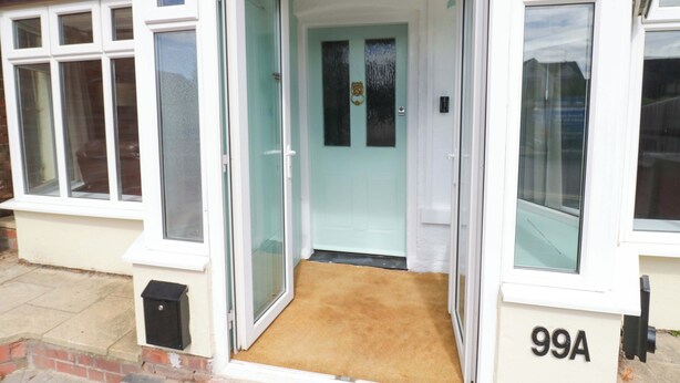 A residential property with a front door, a mailbox, and a number '99A' on the wall.