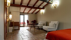 A room with a tiled floor, a sofa, a chair, a small table, and a lamp. There is a door leading to an outdoor area. - MALIA HOME (Catania)