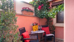 A small outdoor patio with two chairs, a table, and a potted plant. - MALIA HOME (Catania)