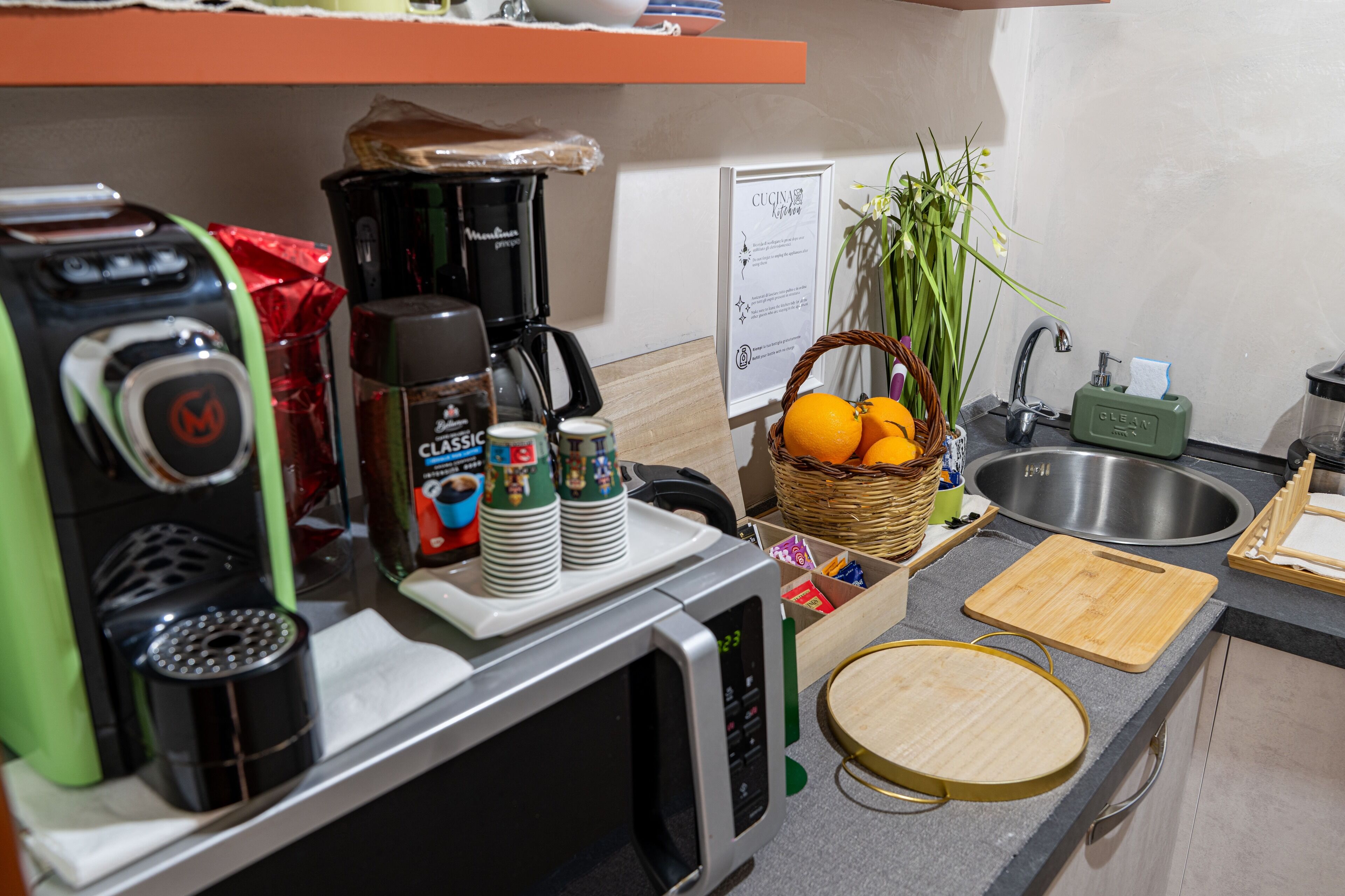 A kitchen with a coffee maker, microwave, and various kitchen items.