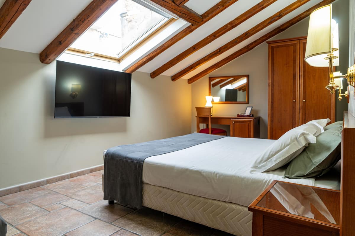 Camera tripla | Una cassaforte in camera, una scrivania, tende oscuranti