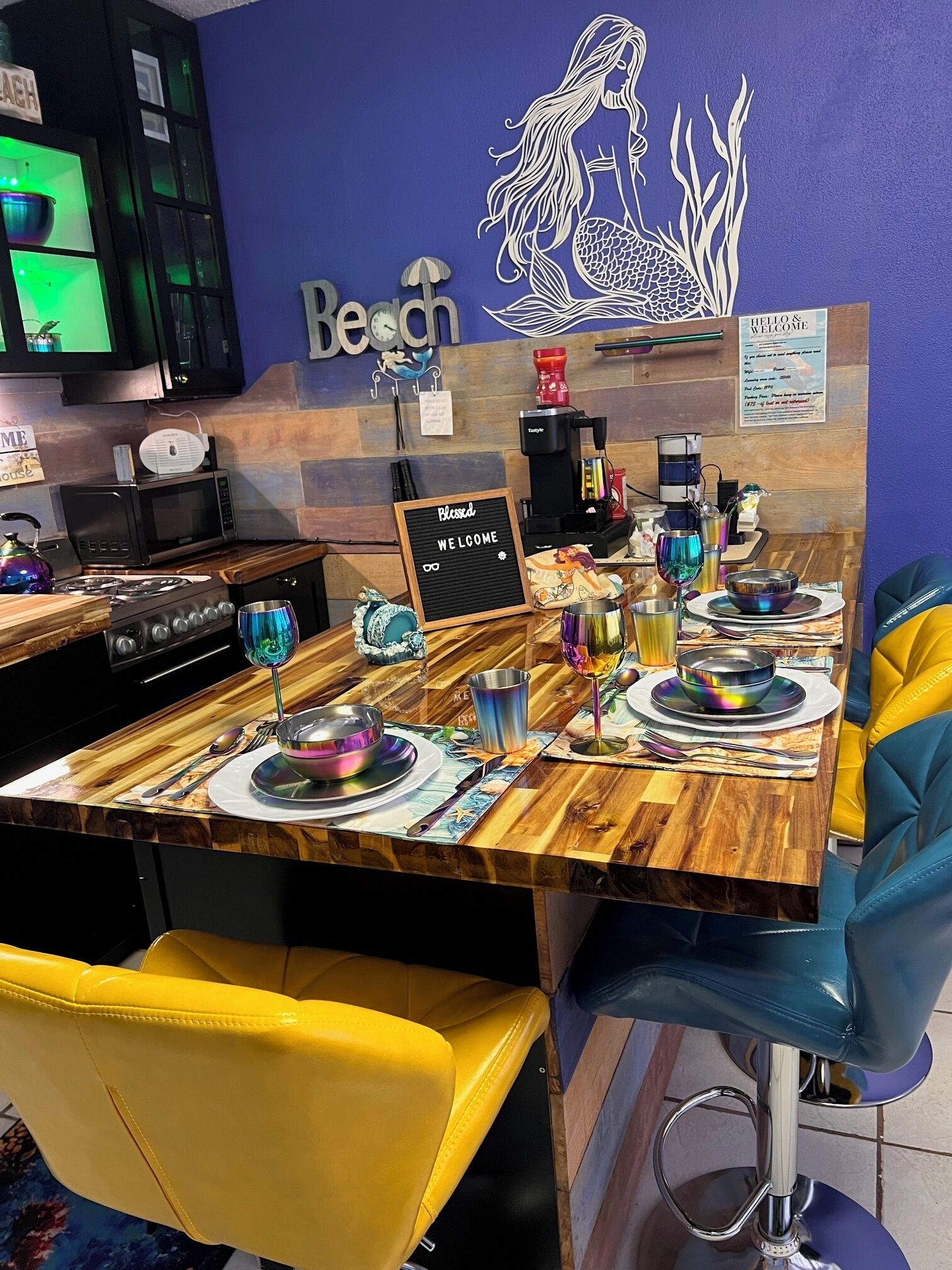 Ein Restaurantinneres mit einem gedeckten Holztisch, einer Kaffeemaschine und einem Schild mit der Aufschrift 'HELLO & WELCOME'.