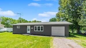 A single-story house with a grey exterior, a front door, a garage, and a driveway.
