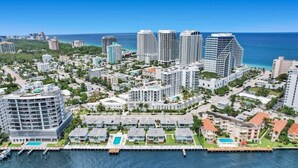 An aerial view of a coastal city with high-rise buildings, a marina, and a clear blue sky. - Fort Lauderdale Luxe - Beach + Rooftop Pools (Fort Lauderdale)