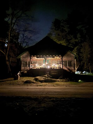 A rustic lodge with a covered front porch and a sign reading "Nicaio's Lodge."