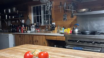 A kitchen with wooden cabinets, a stove, and hanging pots.