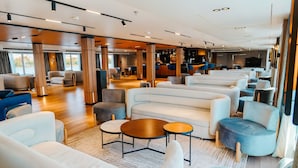 Ein stilvoller Lounge-Bereich mit Sofas, Sesseln und runden Tischen.