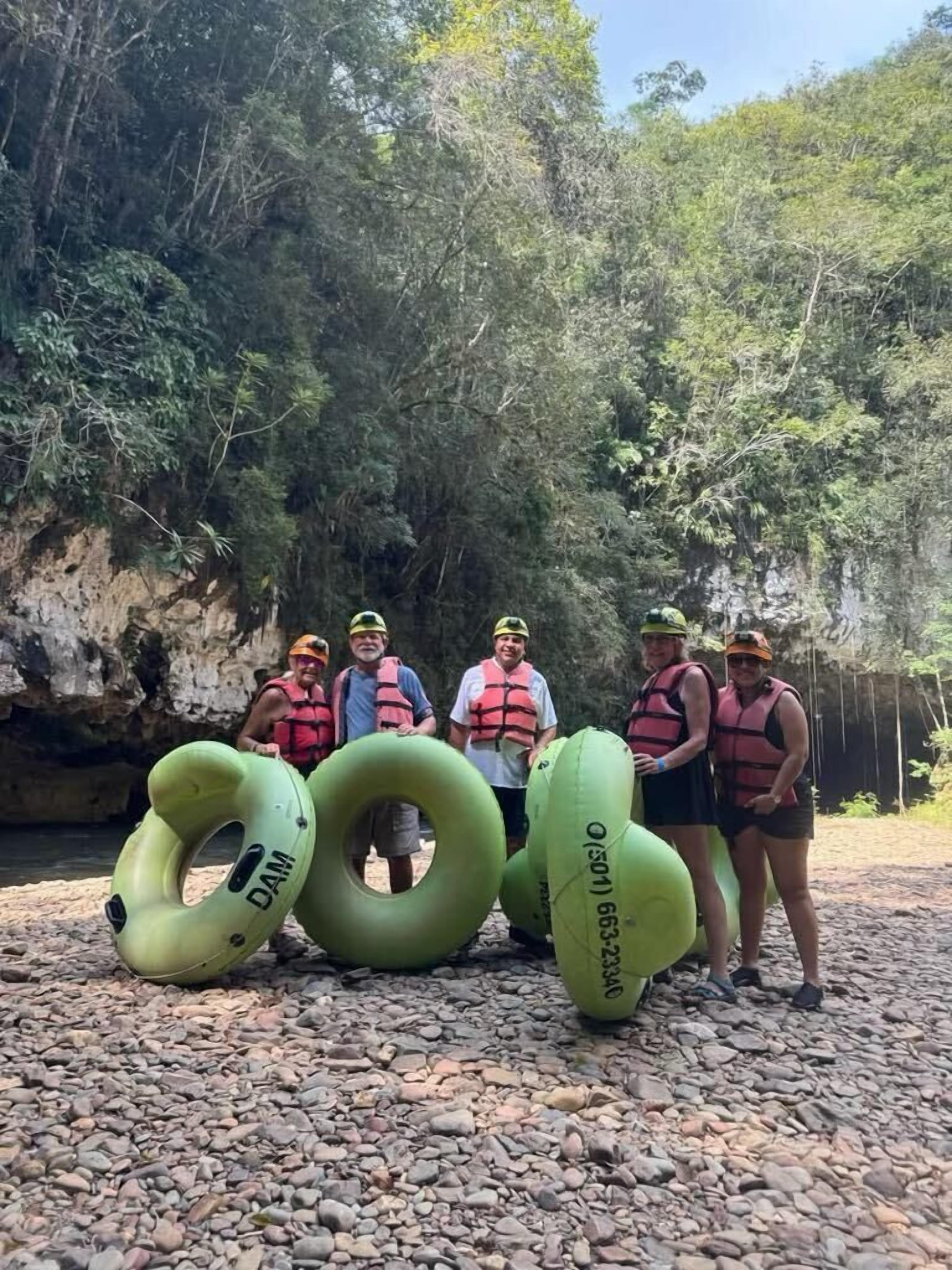 A group of people standing on a rocky surface with green inflatable rings in front of them.