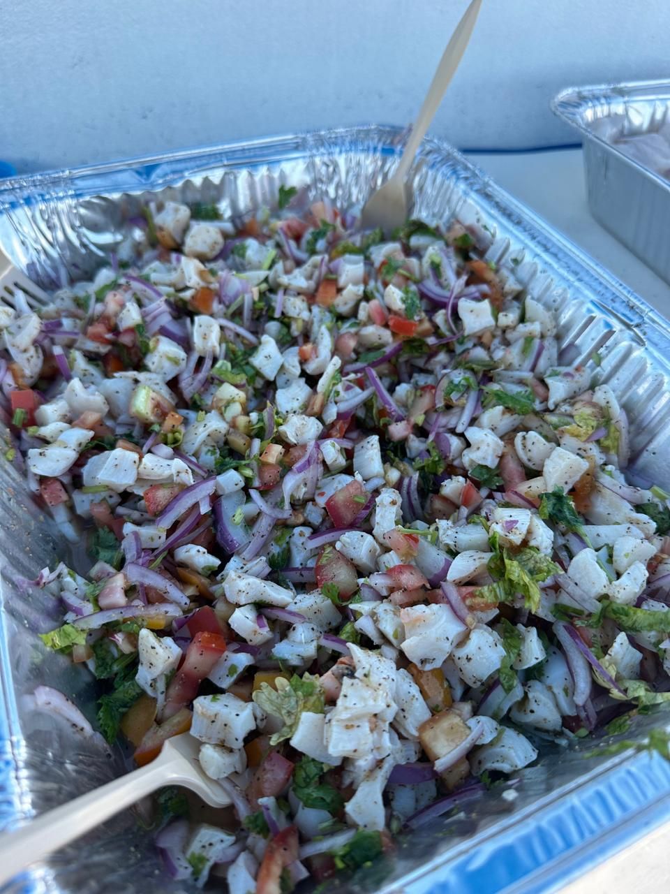 A tray of chopped salad with various vegetables and herbs.