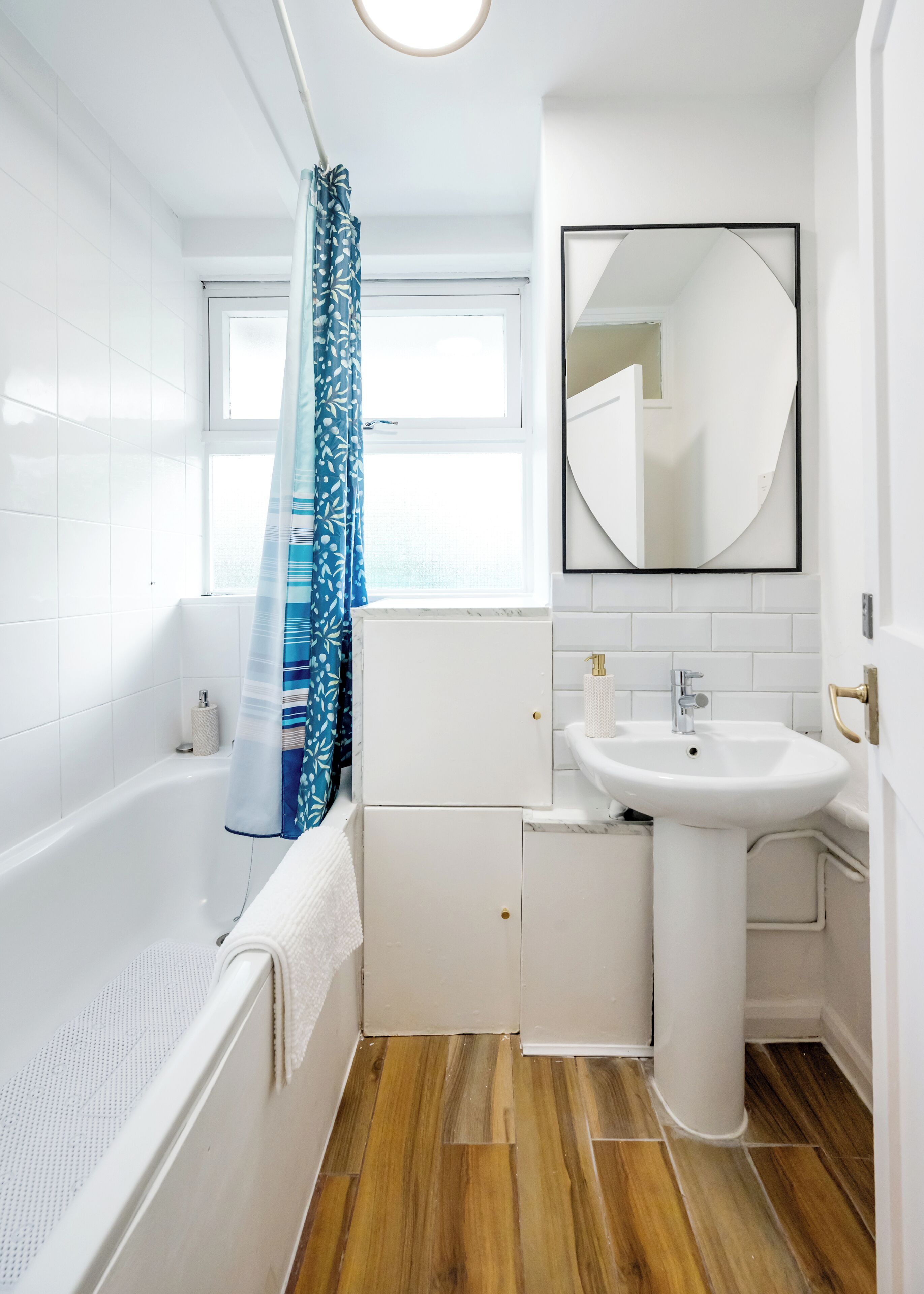 A modern bathroom with a bathtub, a sink, and a mirror.