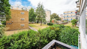 A residential building with a brick facade, multiple windows, and a sign reading "ELGAR HOUSE". - Cozy 2 bedroom London flat in heart of Victoria (London)