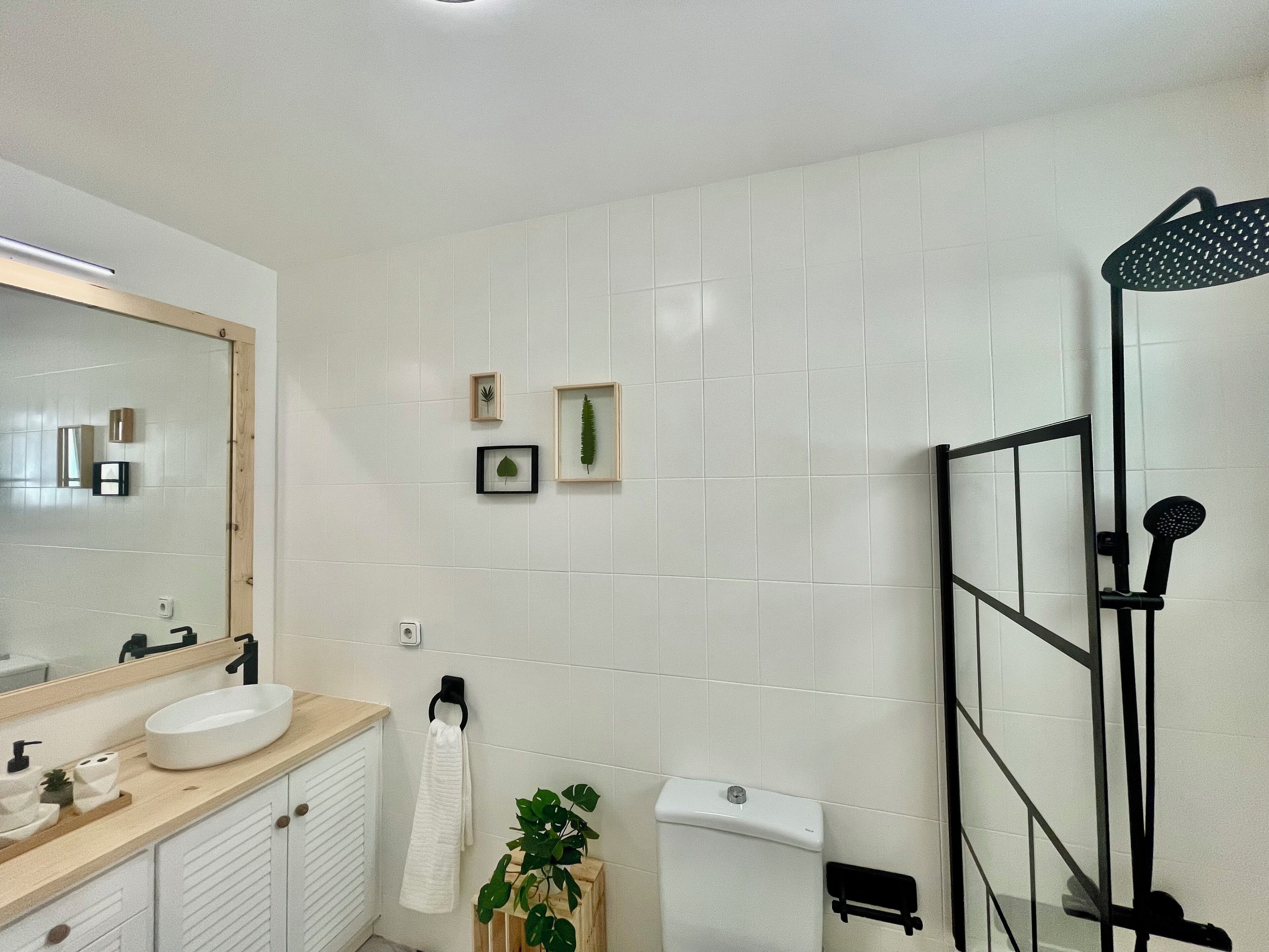 Ein modernes Badezimmer mit großem Spiegel, Waschbecken, Toilette und Dusche.