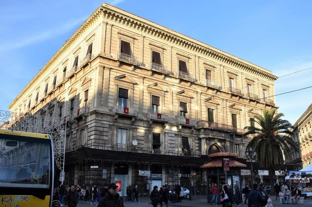 Un immeuble à plusieurs étages de style architectural classique, doté de balcons et d’une entrée au niveau du sol surmontée d’un auvent.