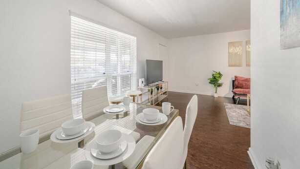 A modern living room with a dining area, a flat-screen TV, and a red sofa. - Pink 1BHK, 5 miles from Downtown + Free Parking (Houston)